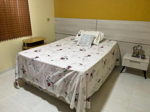 a bedroom with a bed with a white blanket at Apartamento no Icaraí - 2 suítes in Caucaia
