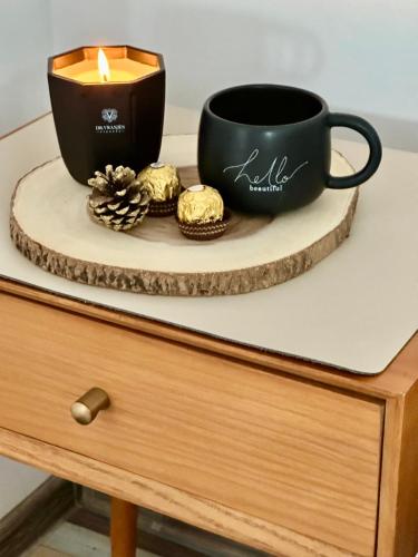a candle and a cup on top of a dresser at Pensiunea Grădina Ascunsa in Bughea de Jos