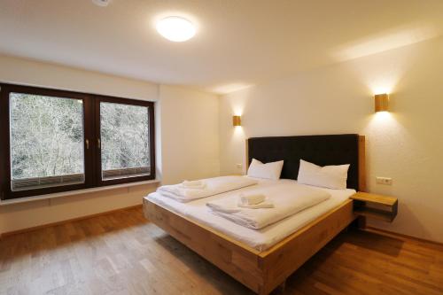 una camera con un grande letto e una grande finestra di Tannenhof Fischbach - Fewo 1 "Felchen" - Schluchsee, 2 Schlafzimmer a Schluchsee