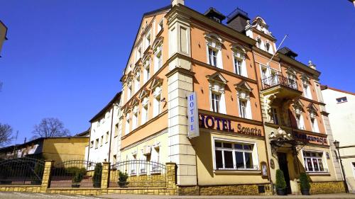 a tall building with a sign on the front of it at Hotel SONATA in Duszniki Zdrój