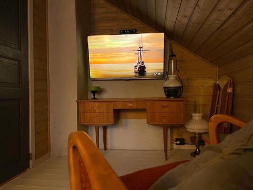 een woonkamer met een tv aan de muur bij Tronstadbu- Traditional cabin in Hellesylt