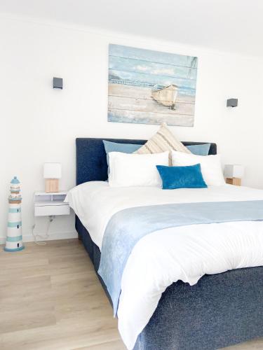 a bedroom with two beds and a painting on the wall at Carvoeiro Beach House in Carvoeiro
