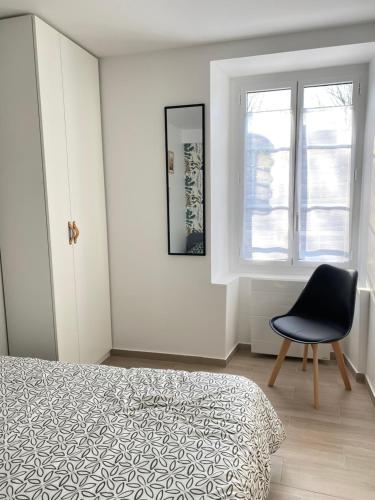 une chambre avec un lit, une chaise et une fenêtre dans l'établissement 2 pièces au cœur du vieux Massy, à Massy