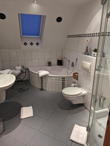 a bathroom with a tub and a toilet and a sink at Ferienwohnung Soreth in Schmallenberg