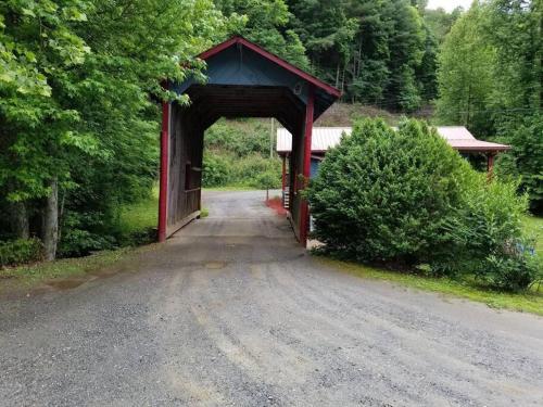 a red covered bridge on a dirt road at Waterwheel Cabin by the Creek in Murphy