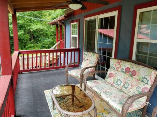 a porch with two chairs and a table and a couch at Waterwheel Cabin by the Creek in Murphy