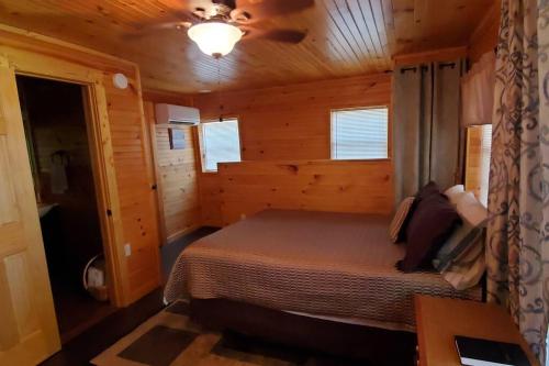 um quarto com uma cama num chalé de madeira em Waterwheel Cabin by the Creek em Murphy