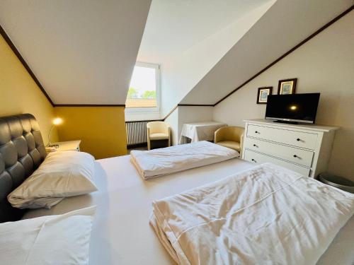 - une chambre mansardée avec 2 lits et une télévision dans l'établissement Appartement mit Bademantelgang zur Wohlfühltherme, à Bad Griesbach im Rottal