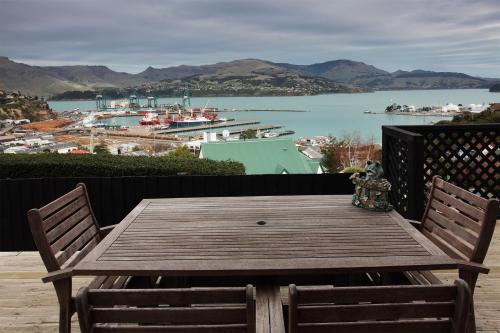 a wooden table on a balcony with a view of a harbor at Harbour Lodge in  Lyttelton