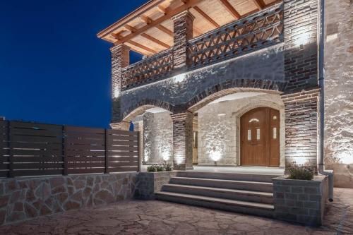 una casa con una puerta de madera y escaleras en Porta del mar Beach Resort en Méson Yerakaríon