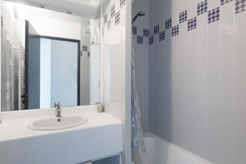 a white bathroom with a sink and a mirror at Appartement Valène in La Flotte