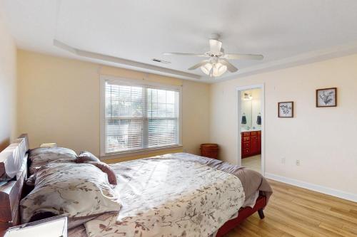 a bedroom with a bed and a ceiling fan at The Lake Keziah House in Southport