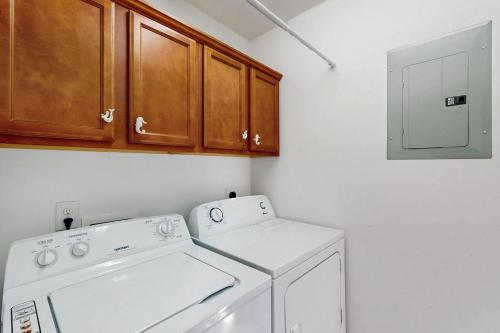 a laundry room with a washing machine and a cabinet at The Lake Keziah House in Southport