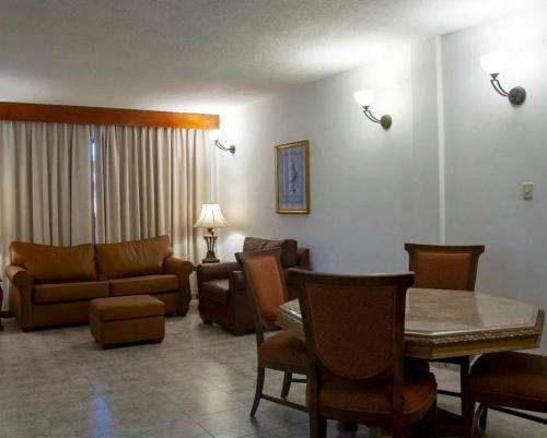 uma sala de estar com um sofá, uma mesa e cadeiras em HOTEL BRISAS PARAGUANÁ em Punto Fijo