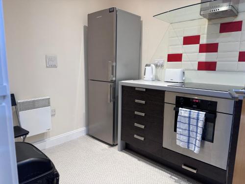 a kitchen with a stainless steel refrigerator and a sink at Luxe Heights Nest in Birmingham