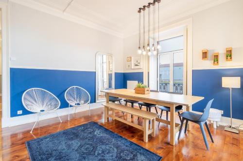 een eetkamer met blauwe muren en een houten tafel en stoelen bij Alegria by Central Hill Apartments in Lissabon