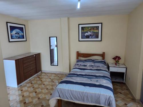 een slaapkamer met een bed en een dressoir bij Habitación Confortable frente al Hospital Regional Ramiro Priale in Huancayo