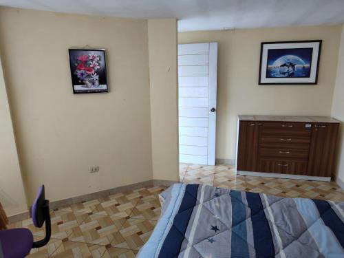 - une chambre avec un lit et une commode sur un mur dans l'établissement Habitación Confortable frente al Hospital Regional Ramiro Priale, à Huancayo