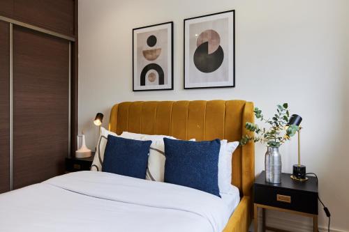 een slaapkamer met een bed met blauwe kussens bij The Harlesden Escape - Spacious 3BDR Flat with Balcony in Londen