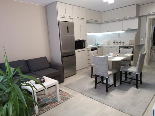 cocina y sala de estar con sofá y mesa en City Apartment en Gotse Delchev
