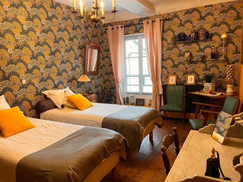 ein Hotelzimmer mit 2 Betten, einem Tisch und einem Fenster in der Unterkunft les loges du chaudron in La Chapelle-aux-Choux