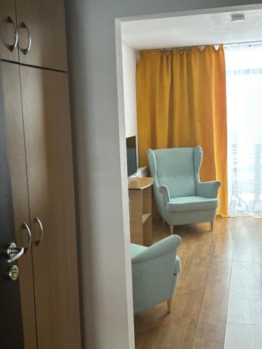 a room with a blue chair and a chair and a window at Pensiunea Bike&Bed in Moieciu de Jos