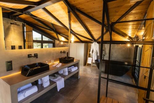 a bathroom with two sinks in a room with wooden ceilings at Spa Villas Nafpaktos in Nafpaktos