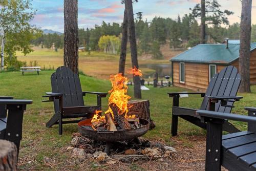 a fire pit in a yard with two chairs at The Monet- BHBungalows #1 in Custer