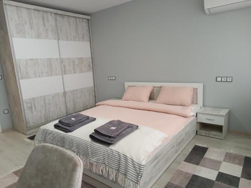 a bedroom with a bed with pink pillows on it at City Apartment in Gotse Delchev