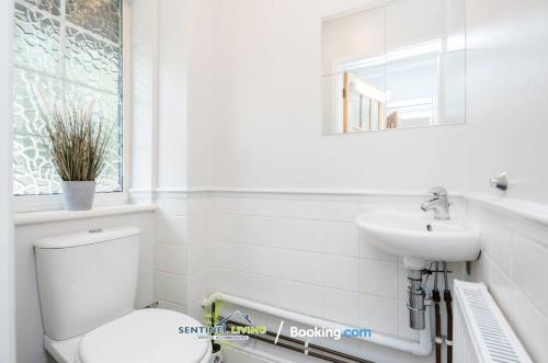 a white bathroom with a toilet and a sink at Ascot, Pet Friendly, Detached 4 Bedroom House By Sentinel Living Short Lets & Serviced Accommodation Windsor Ascot Maidenhead With Free Parking in Ascot
