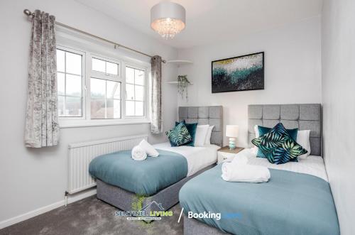 a bedroom with two beds and a window at Ascot, Pet Friendly, Detached 4 Bedroom House By Sentinel Living Short Lets & Serviced Accommodation Windsor Ascot Maidenhead With Free Parking in Ascot