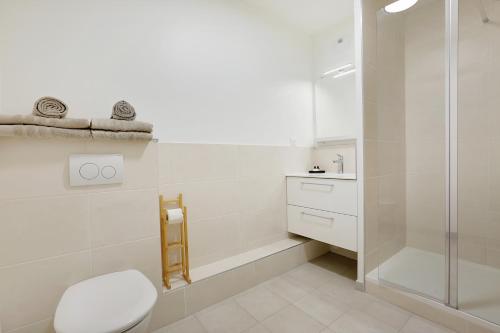 une salle de bain blanche avec toilettes et douche dans l'établissement La Résidence Alpha Viroflay 101 - 1 chambre - 4 pers, à Viroflay