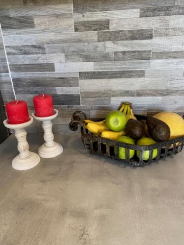 a basket of fruit sitting next to two candles at Zante Star Summer House in Zakynthos Town