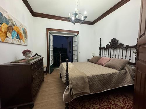 Casa de São Braz في Landim: غرفة نوم بسرير وخزانة ومرآة