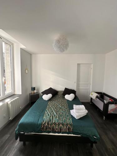 1 dormitorio con 1 cama verde y 2 almohadas en Appart cocooning, en Saint-Germain-des-Fossés