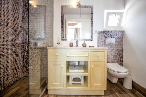 a bathroom with a sink and a toilet and a mirror at Villa de la Plage in Albufeira