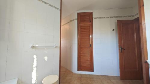 bagno con servizi igienici e porta in legno di Merbea - Magnífica Villa en Peñíscola a Peñíscola