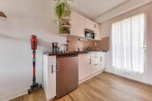 une cuisine avec des placards blancs et une grande fenêtre dans l'établissement 300 m de la plage - Maison pour 4 avec jardin, à Sarzeau