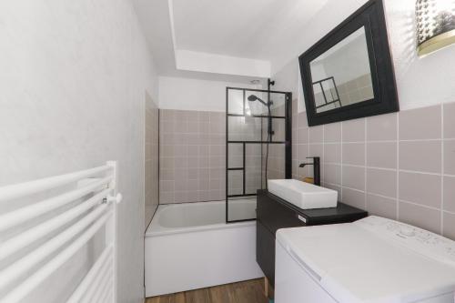 une salle de bain avec une baignoire, un lavabo et des toilettes dans l'établissement 300 m de la plage - Maison pour 4 avec jardin, à Sarzeau