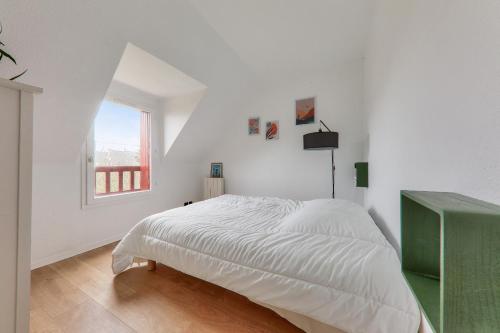 une chambre blanche avec un lit et une fenêtre dans l'établissement 300 m de la plage - Maison pour 4 avec jardin, à Sarzeau