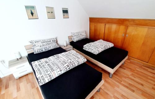 Duas camas num pequeno quarto com pisos em madeira em Gemütliche Monteurwohnung in Oberhausen em Oberhausen