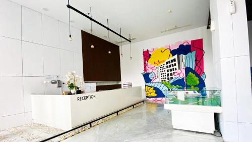 a lobby with a reception counter with a mural on the wall at Patraland Urbano Apartment by SiniBobo in Bulanbulan