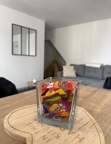 a glass vase filled with colorful confetti on a table at Appart cocooning in Saint-Germain-des-Fossés