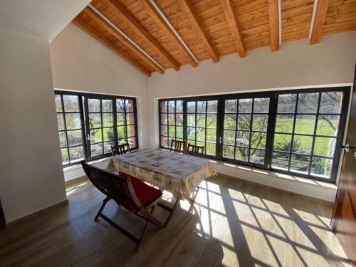 a room with a table and chairs and windows at Emerald Apartment in Valmontone