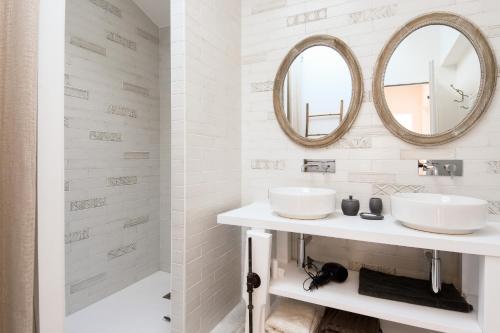 a white bathroom with two sinks and mirrors at Maison pour 6 au coeur de Bretignolles-sur-Mer in Brétignolles-sur-Mer