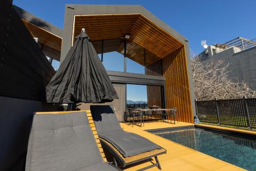 a house with a pool and a chair and an umbrella at Spa Villas Nafpaktos in Nafpaktos