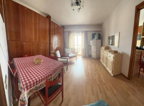 a living room with a table and a kitchen at Aremogna Appartamento Sulle Piste da Sci in Roccaraso