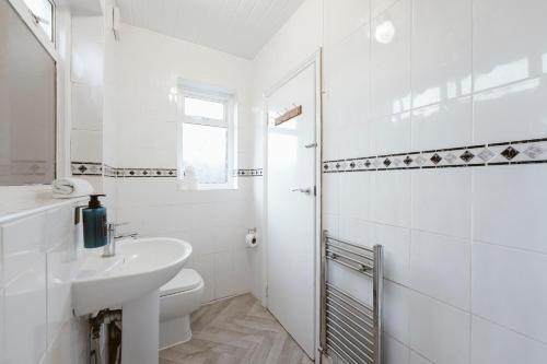 a white bathroom with a sink and a toilet at Stratford Double Rooms - 29 in London