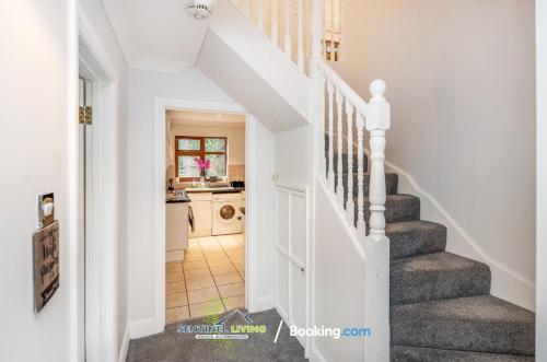 uma escada numa casa com uma escada branca em 4 Bedroom House By Sentinel Living Short Lets & Serviced Accommodation Windsor Ascot Maidenhead With Free Parking & Pet Friendly em Maidenhead