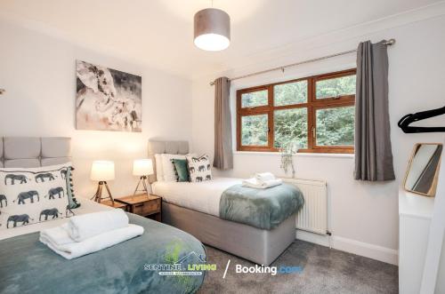 een slaapkamer met 2 bedden en een raam bij 4 Bedroom House By Sentinel Living Short Lets & Serviced Accommodation Windsor Ascot Maidenhead With Free Parking & Pet Friendly in Maidenhead